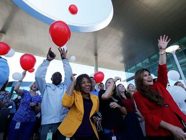 Wotsa Koutoglo (center) and Lenie Tumminia watch as balloons are released by employees after...