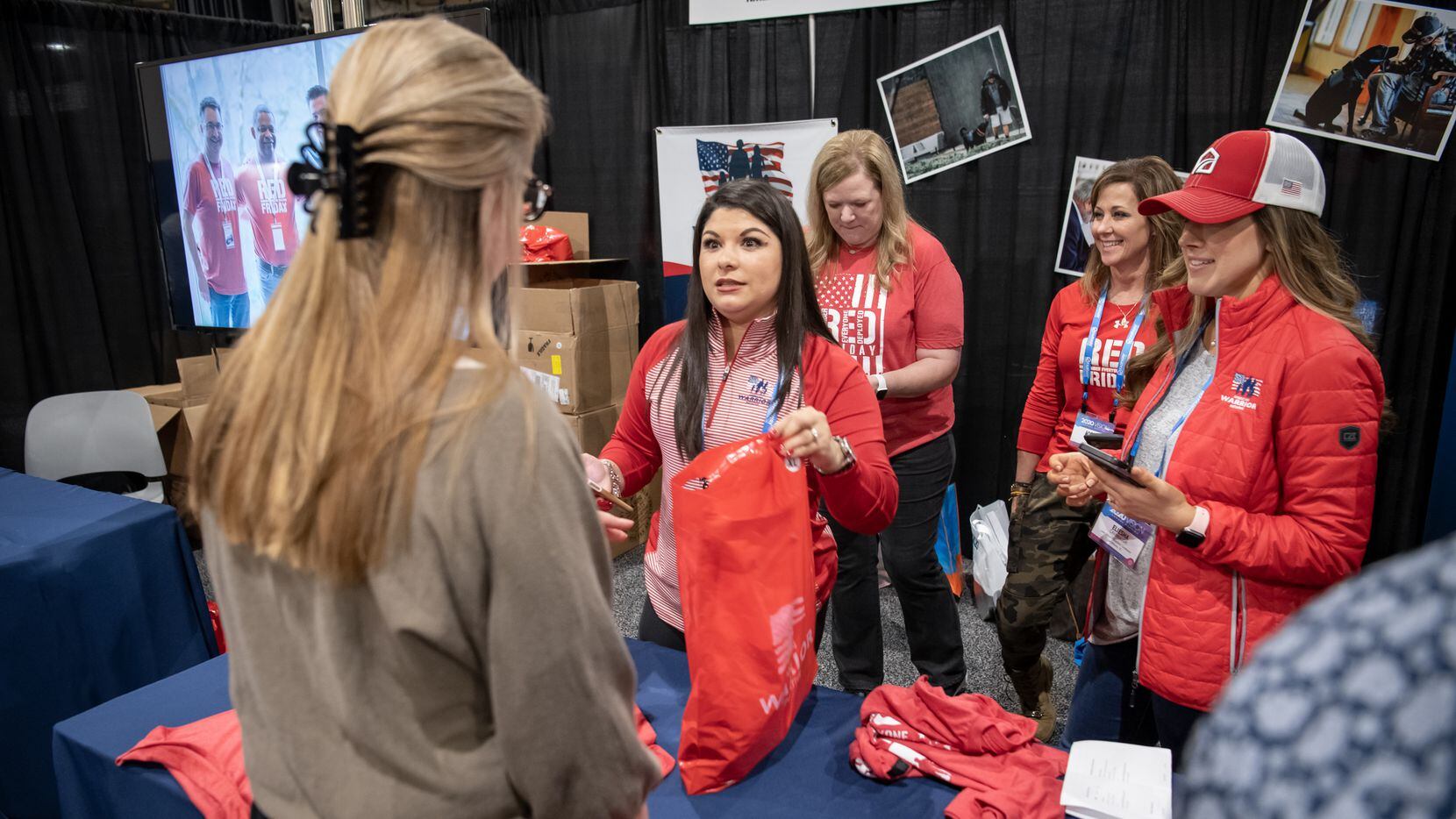 Fairway Independent Mortgage Corp. team members handed out American Warrior Initiative shirts at the company's annual meeting in 2020. The company's employees wear red on Fridays to honor deployed military members.