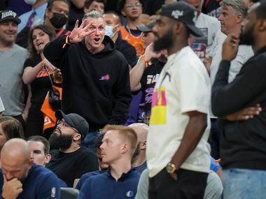 A Phoenix Suns fans holds up four fingers toward Dallas Mavericks forward Tim Hardaway Jr....