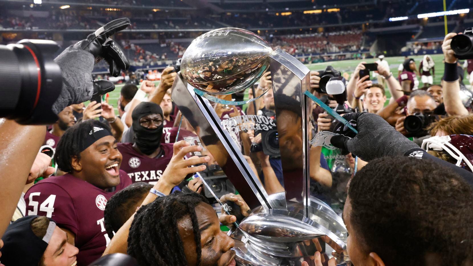 Texas A&M players celebrate after winning against Arkansas at AT&T Stadium in Arlington on...