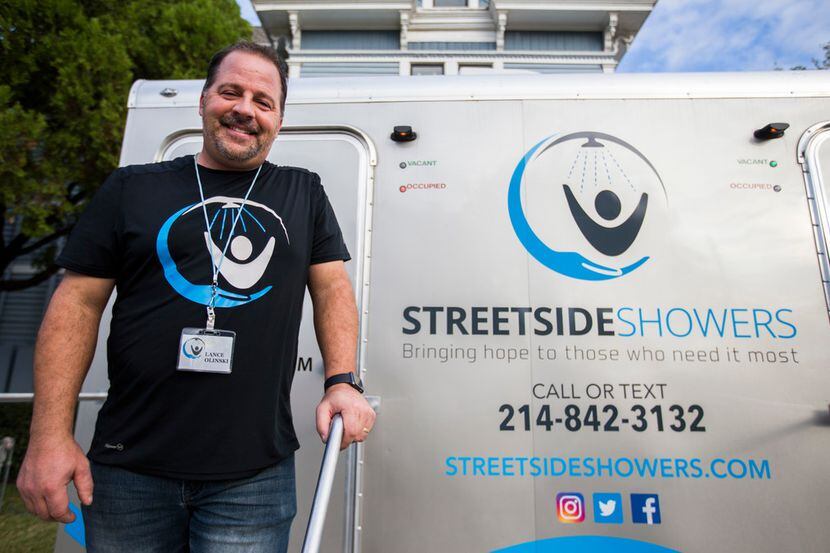 Lance Olinski of Streetside Showers poses for a photo next to his mobile showers parked...