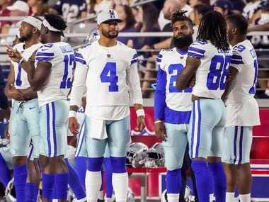 Dallas Cowboys quarterback Dak Prescott (4) watches from the sidelines with wide receiver Cedrick Wilson (1), wide receiver Michael Gallup (13), running back Ezekiel Elliott (21), wide receiver CeeDee Lamb (88) and wide receiver Amari Cooper (19) during the second quarter of an NFL football game against the Arizona Cardinals at State Farm Stadium on Friday, Aug. 13, 2021, in Glendale, Ariz.