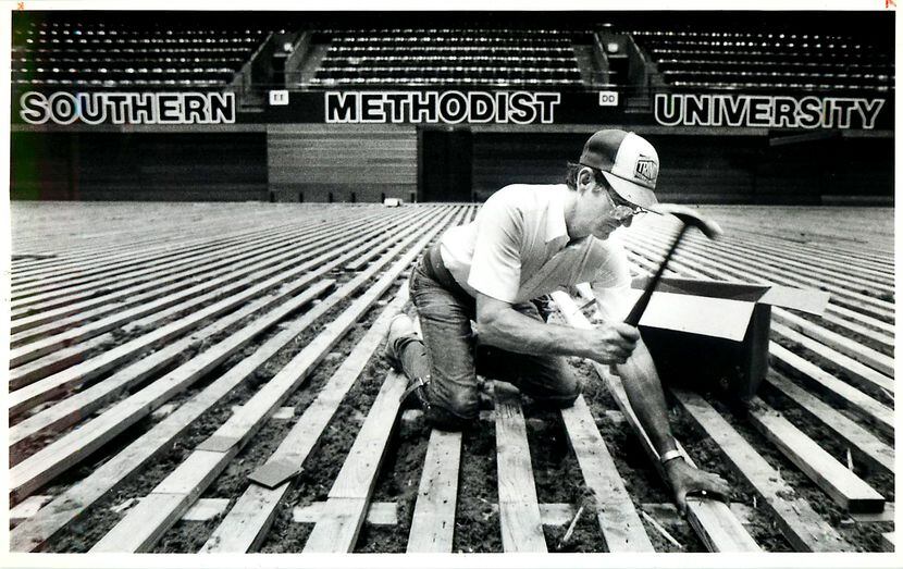 Original caption (revised to add date and city): "Wayne Smith, of Trinity Floor, hammers...