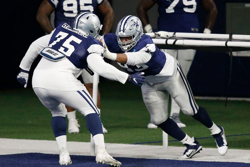 El tacle defensivo de los Dallas Cowboys, Gerald McCoy (der), practica con su compañero...