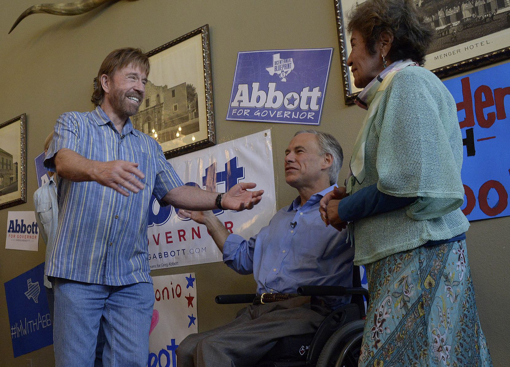 Then-Texas Attorney General Greg Abbott, middle, introduces actor Chuck Norris to his mother-in-law, Mary Lucy Phalen, during an October 2014 event in San Antonio as Abbott first ran for governor.