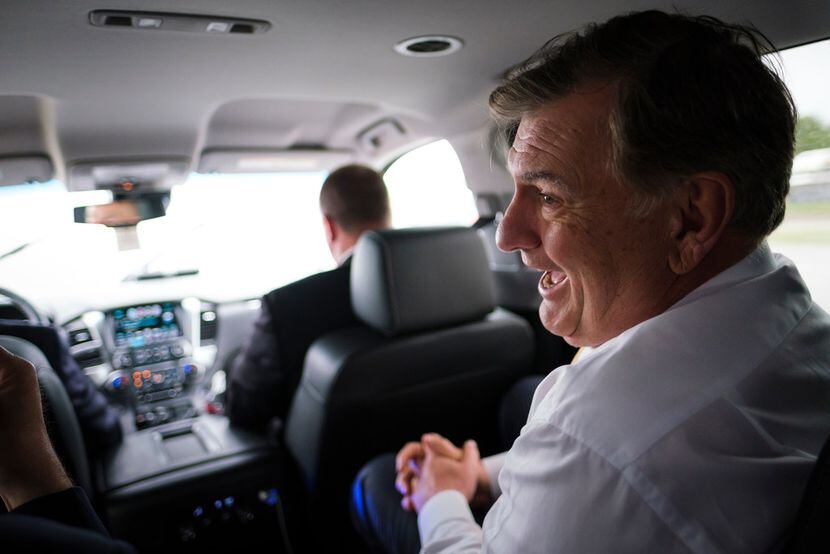 Dallas Mayor Mike Rawlings laughs while riding from Dallas City Hall to an offsite City...