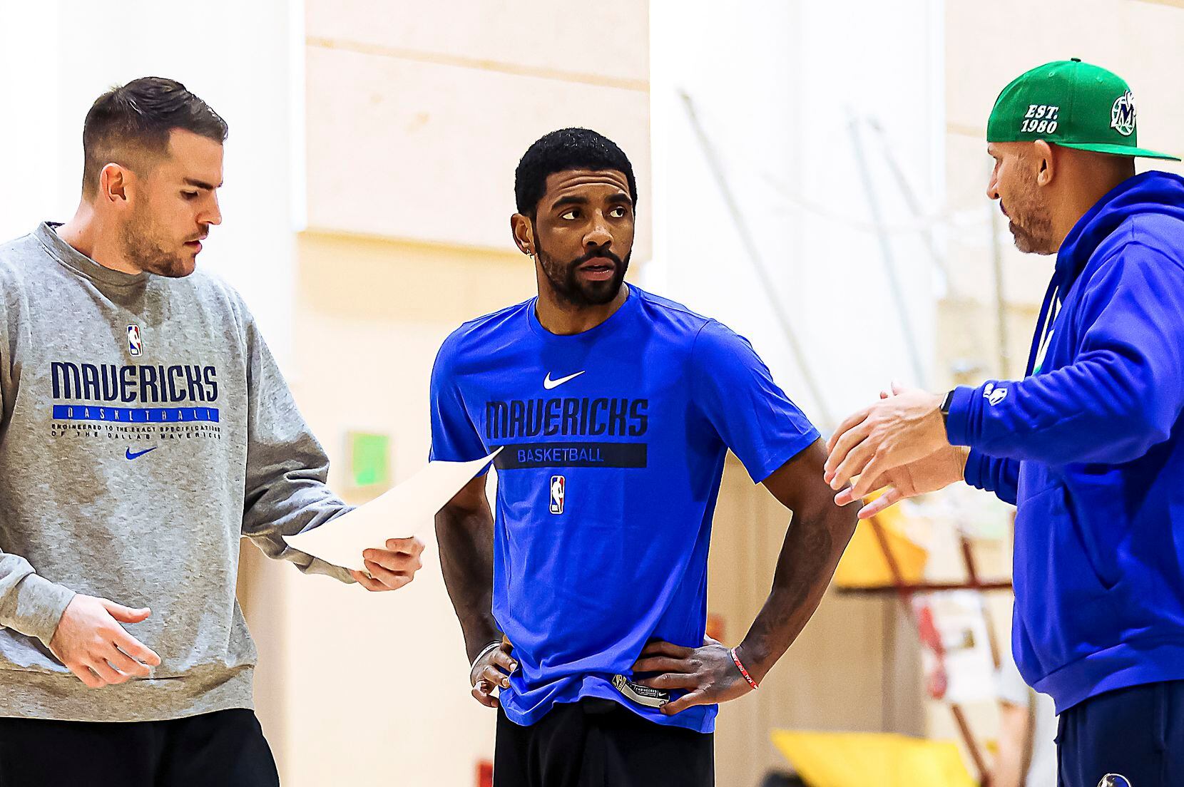 Dallas Mavericks guard Kyrie Irving talks with head coach Jason Kidd (right) and assistant...