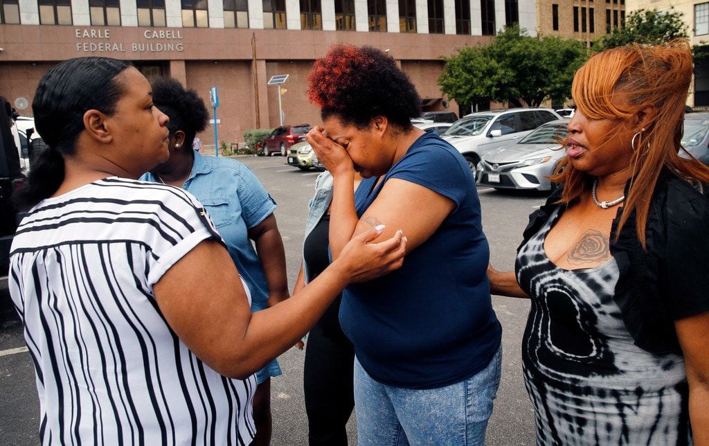 Shaquna Persley (center), mother of slain 13 yr-old Shavon Randle, is comforted by family as...