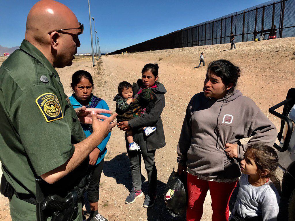 Joe Romero, a border patrol agent, talks to mothers from Guatemala who are saying their...
