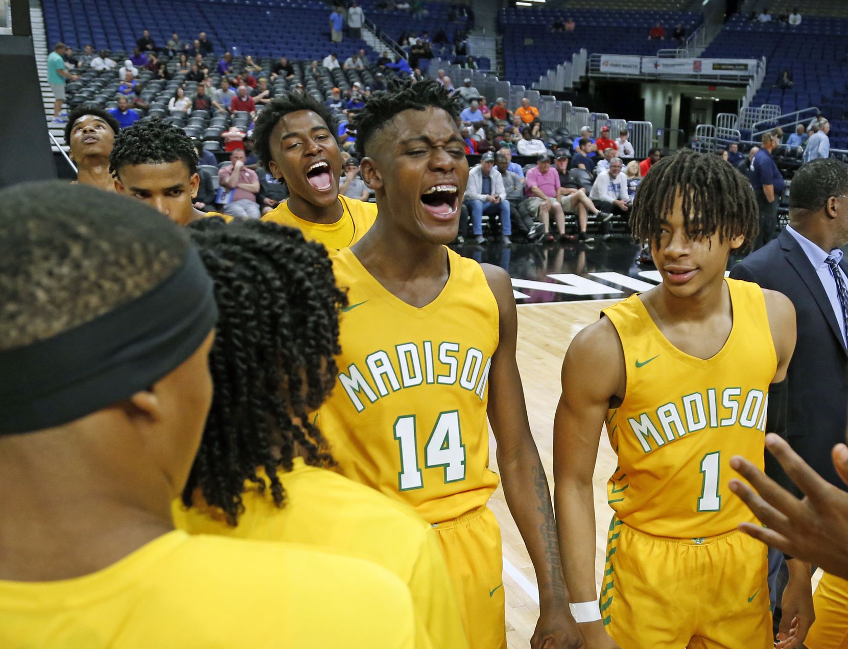 Madison center Leonard Miles IV #14 celebrates with the rest of his team. Madison defeated...