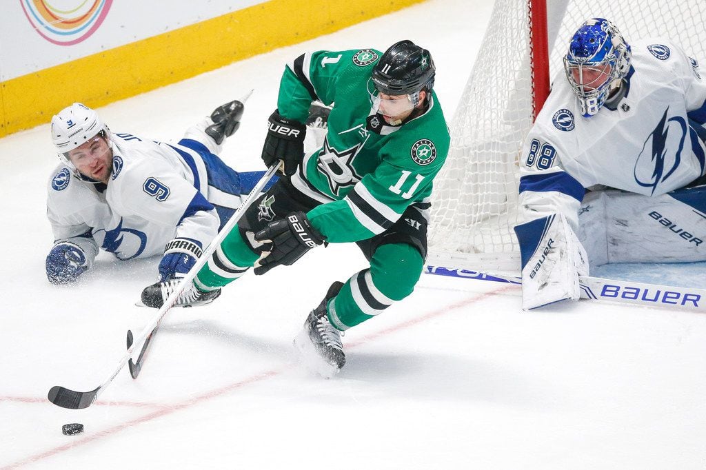 Dallas Stars center Andrew Cogliano (11) swings around the goal for an attempted, and...