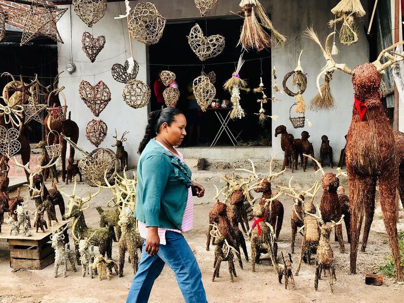 Olivia Carranza walks by a shop selling reindeer made of straw in the town of Saucedo on...