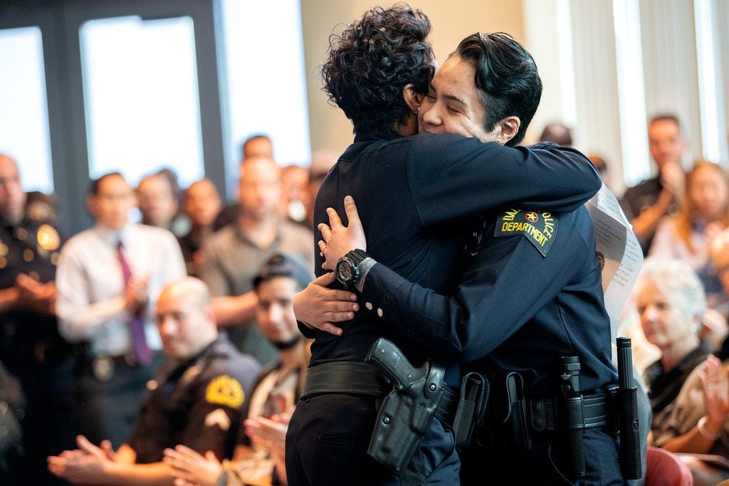 Dallas police officer Crystal Almeida, right, receives a hug from Chief U. Renee Hall.