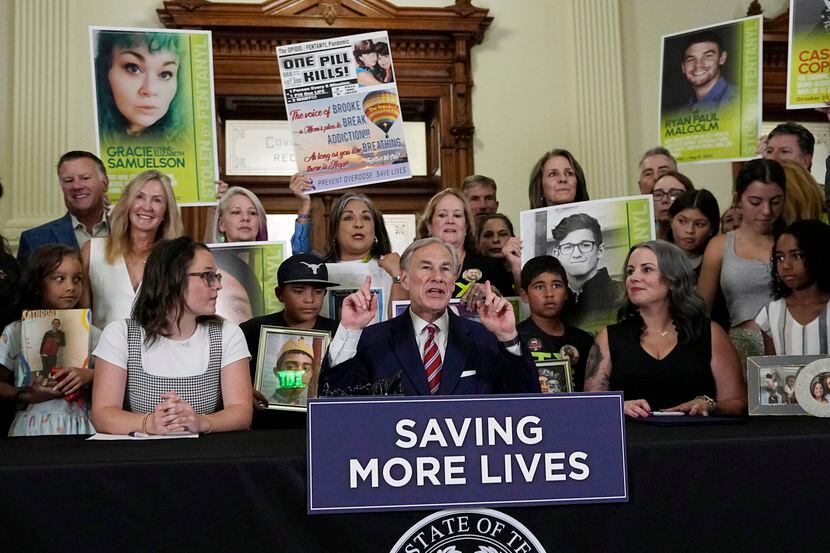 Photos of family members who died of fentanyl related deaths stand behind Texas Gov. Greg...