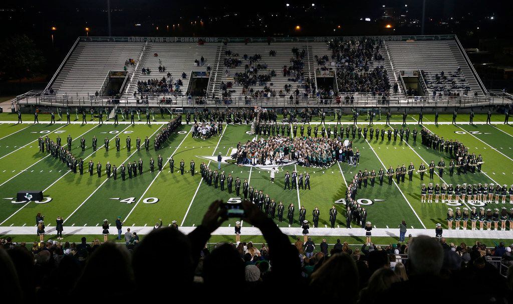 Members of the Southlake Carroll marching band, drill team and others celebrate the...