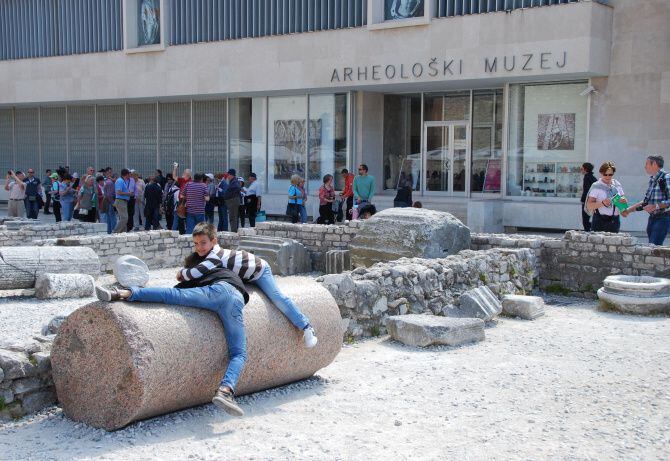 Kids play on an ancient column from the time of the Roman empire in Zadar’s historic old...