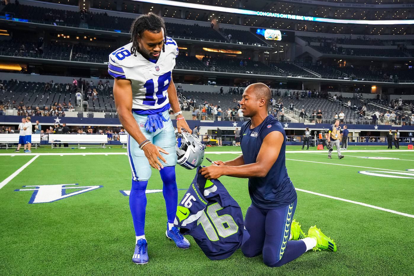 Dallas Cowboys wide receiver Jalen Tolbert (18) gets an autographed jersey from Seattle...