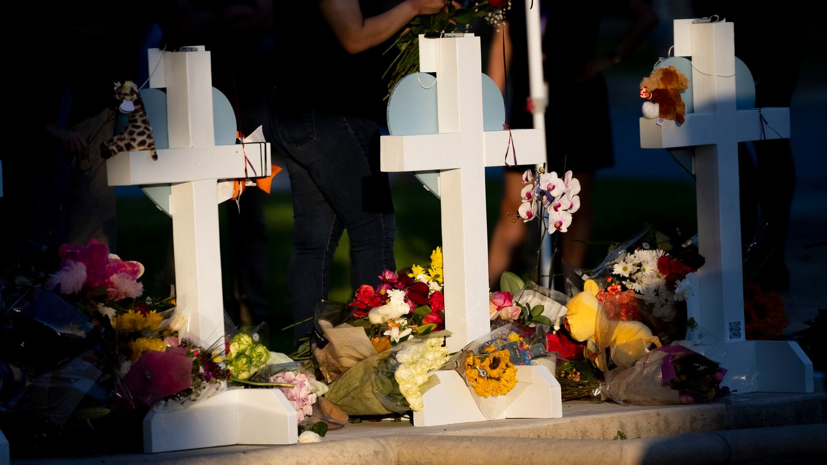 People stand in front of crosses honoring the 19 children and two adults killed in the Robb...