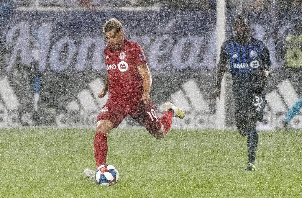 Toronto FC's Alejandro Pozuelo (10) breaks away from Montreal Impact's Michael Azira (32) as rain falls during second-half MLS soccer match action in Montreal, Saturday, July 13, 2019. (Graham Hughes/The Canadian Press via AP)