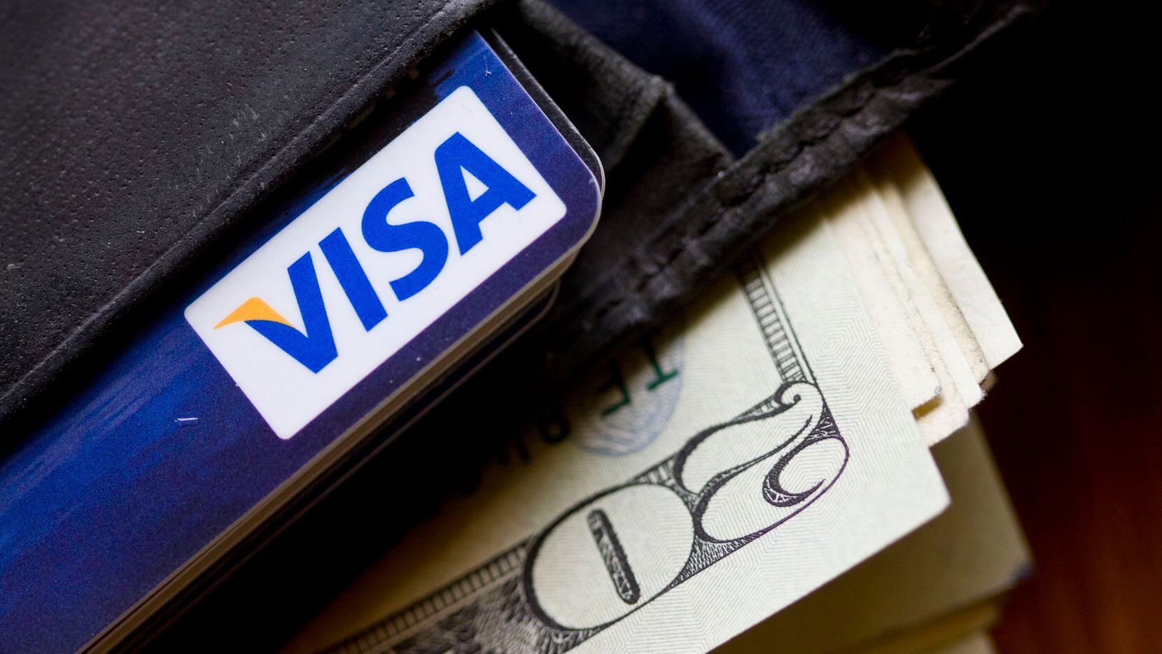 In this Feb. 2, 2011, file photo, a wallet containing cash and a Visa card is displayed in...