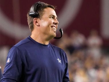 Dallas Cowboys offensive coordinator Kellen Moore smiles on the sidelines during the second half of a preseason NFL football game against the Arizona Cardinals at State Farm Stadium on Friday, Aug. 13, 2021, in Glendale, Ariz.