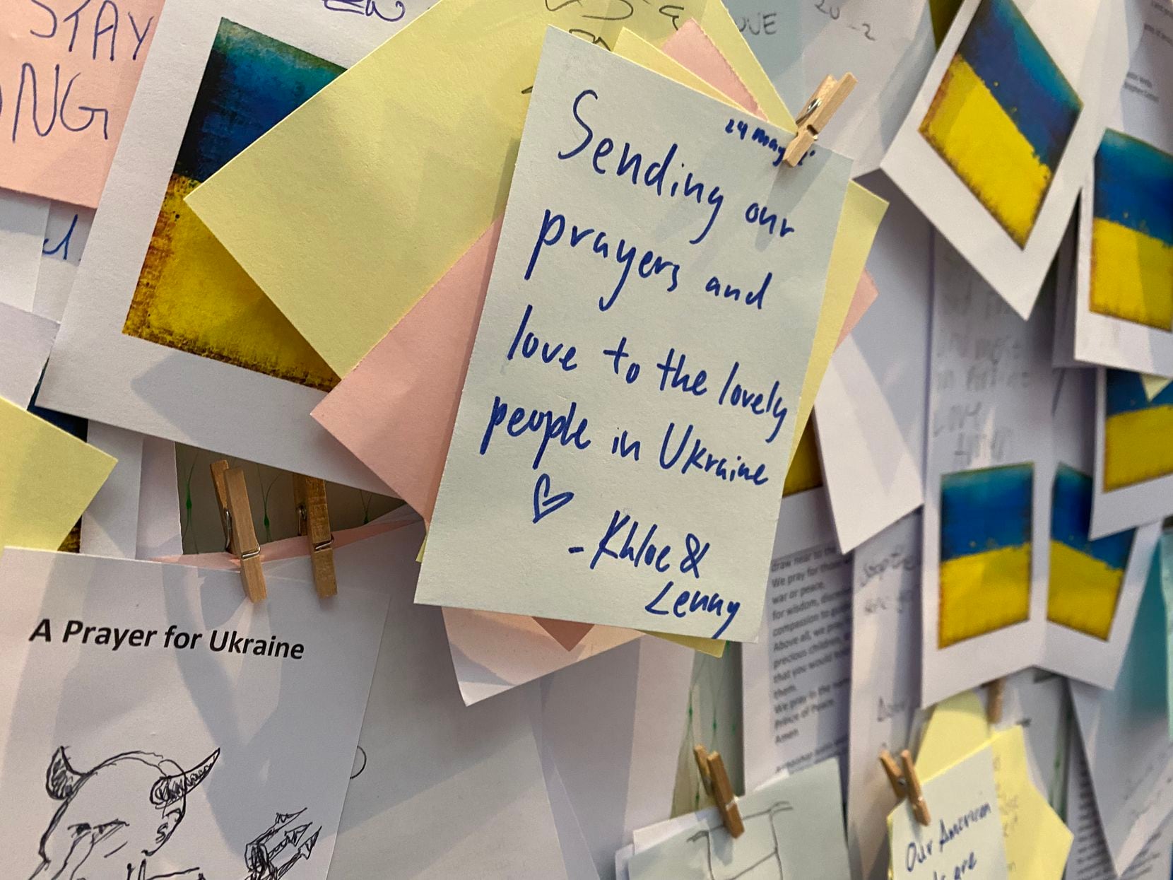 Handwritten prayers for Ukraine, which were clipped to a partition at Bath Abbey, are from...