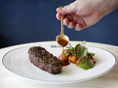 Chef Bruno Davaillon pours sauce on the Bison Au Poivre, photographed at Bullion in 2018. Founding executive chef Davaillon is stepping away from day-to-day operations at the downtown Dallas French restaurant.