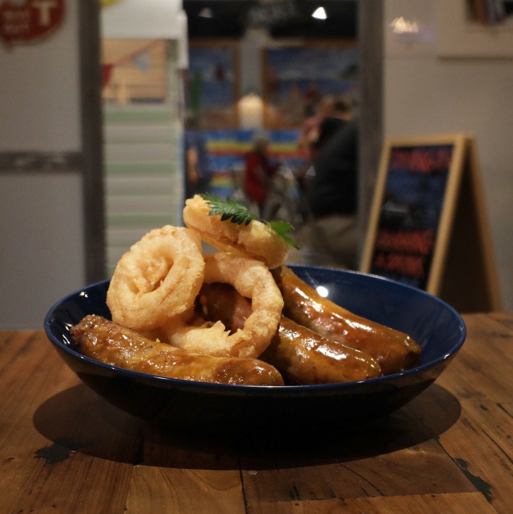 Bangers and mash, topped by perfectly fried onion rings