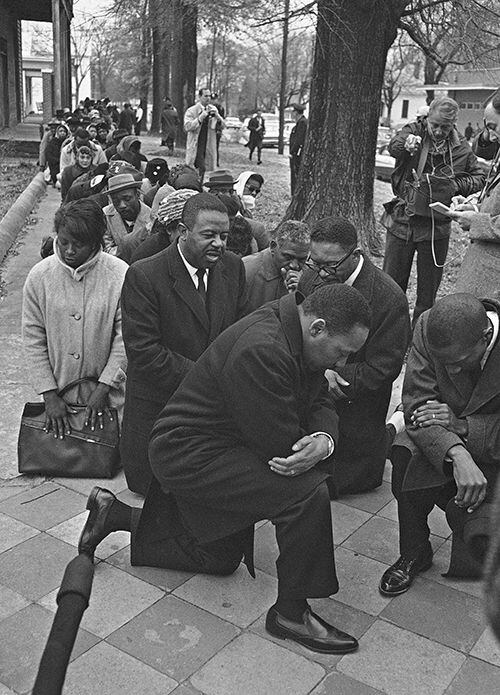 The Rev. Martin Luther King Jr. leads a group of civil rights workers in prayer on Feb. 1,...