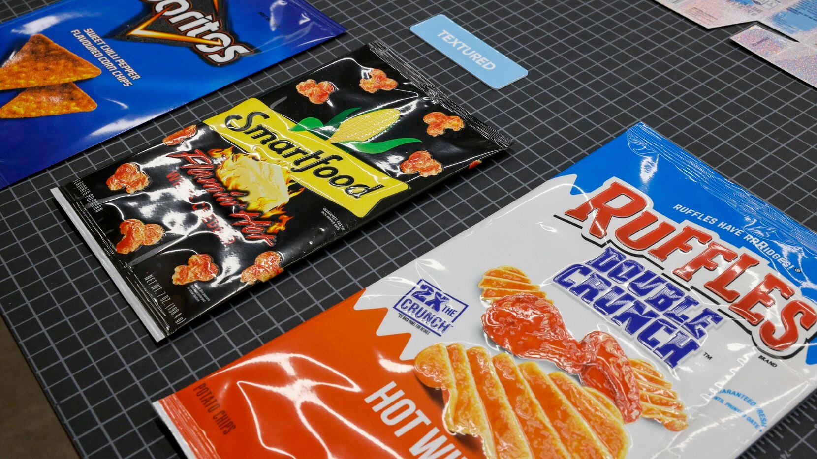 Textured film used for packaging various snacks is displayed on a table in the packaging and...