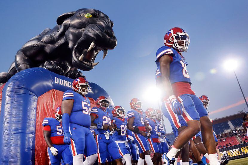 The Duncanville Panthers football team walks in unison onto the field to face South Oak...