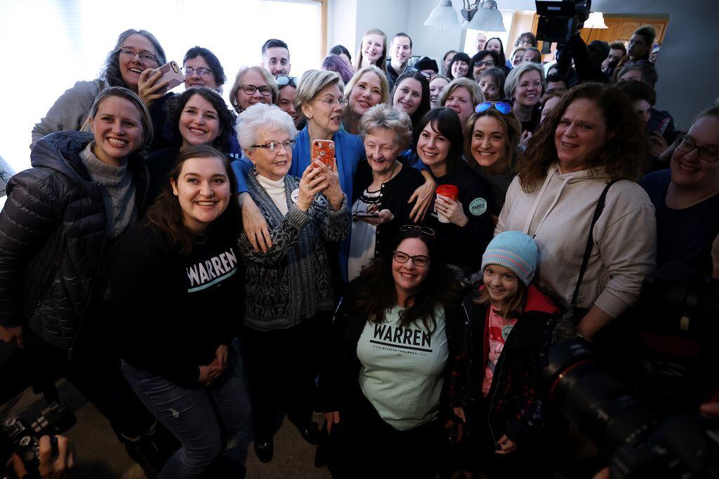 Sen. Elizabeth Warren poses for a photo with volunteers before they go canvassing on Feb....
