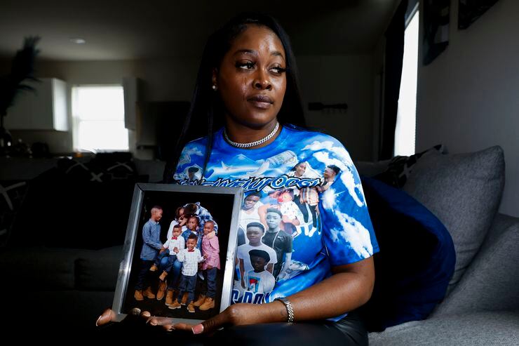 Yadira Campbell poses for a photo holding a family photo which includes her 16-year-old son,...