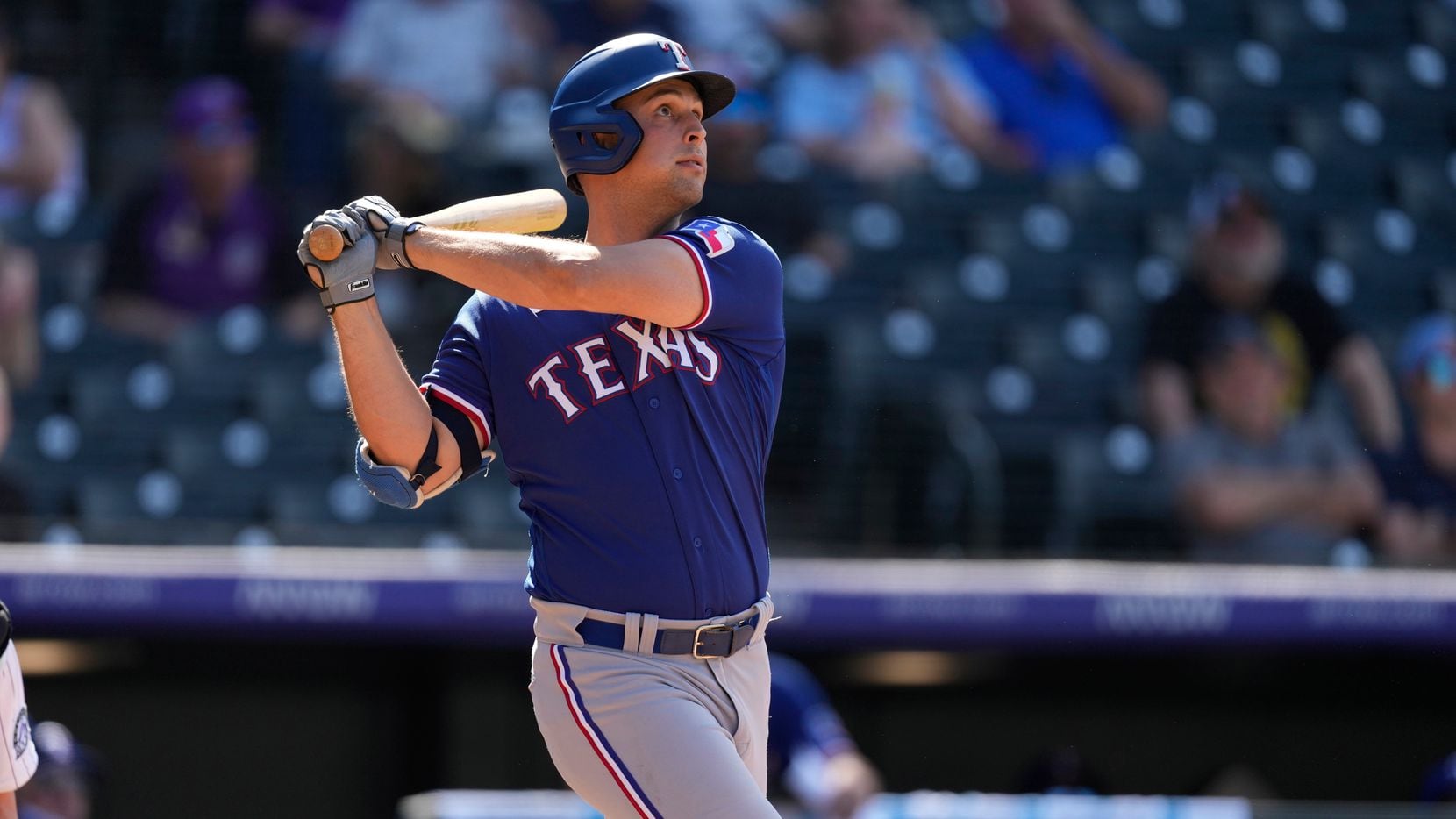 Texas Rangers' Nathaniel Lowe follows the flight of his three-run home run off Colorado...