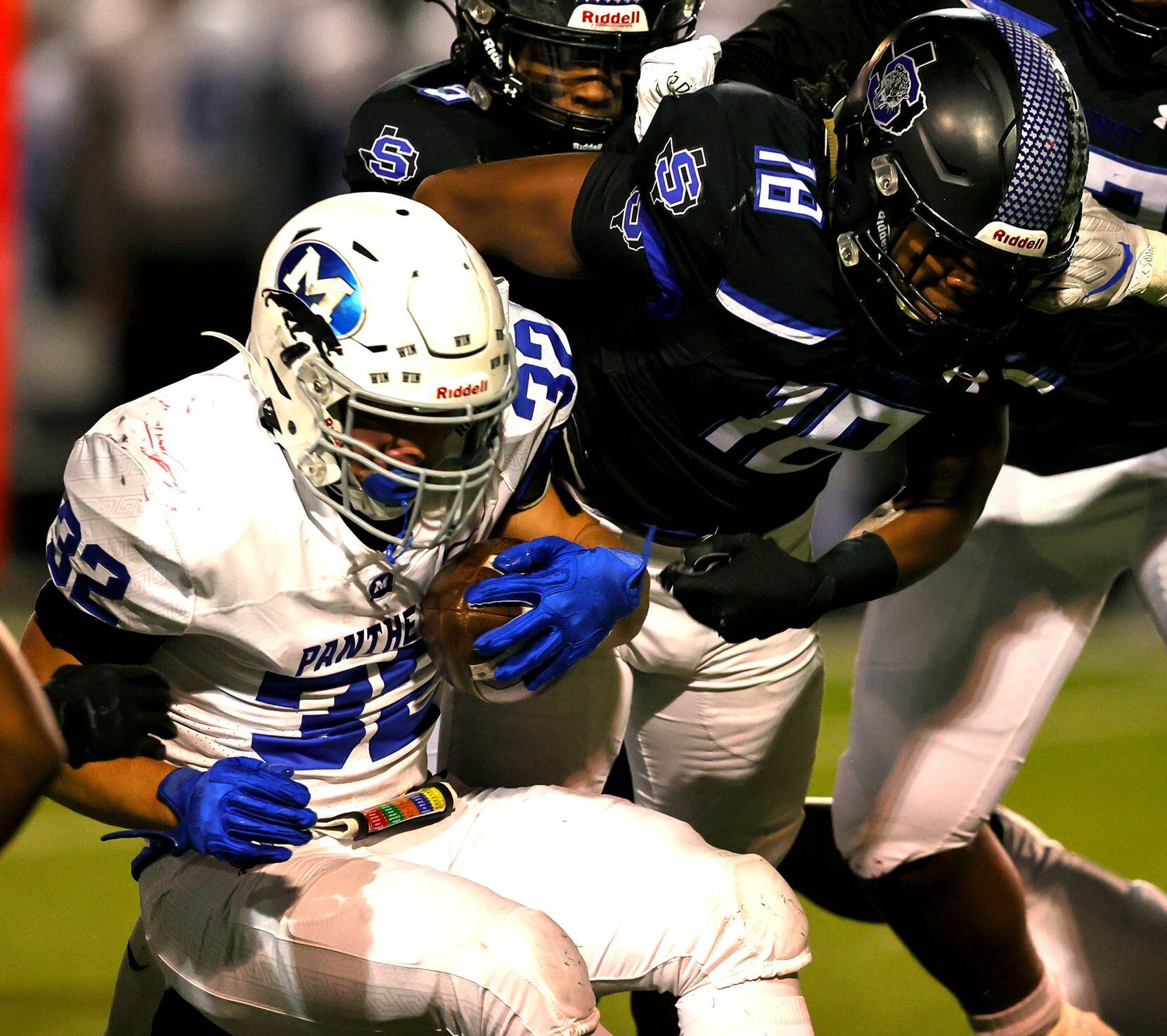 Midlothian running back Michael Garber (32) gets stuffed for no gain against Mansfield Summit linebacker Kyland Reed (18) during the first half of the 5A Division I Region I semifinal high school football playoff game played on November 26, 2021 at Gopher-Warrior Bowl in Grand Prairie.  (Steve Nurenberg/Special Contributor)