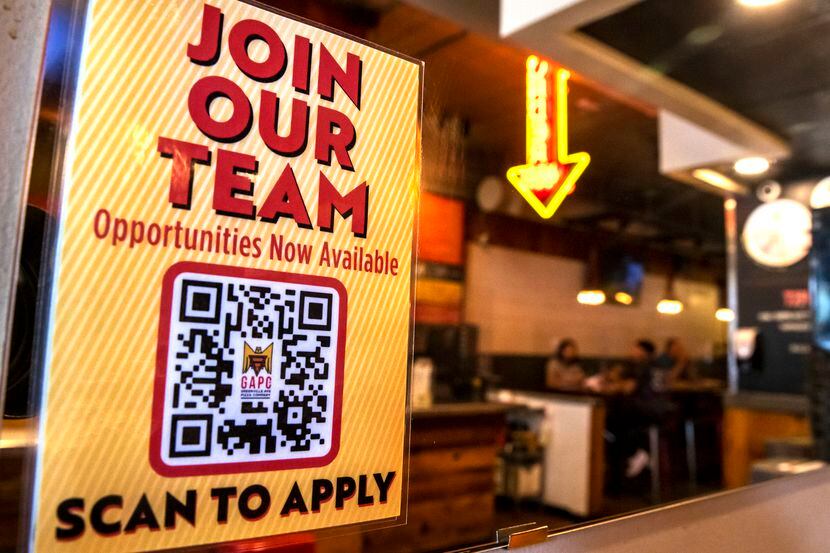 Un cartel indica que hay trabajos disponibles en una pizzería en Greenville Avenue en...