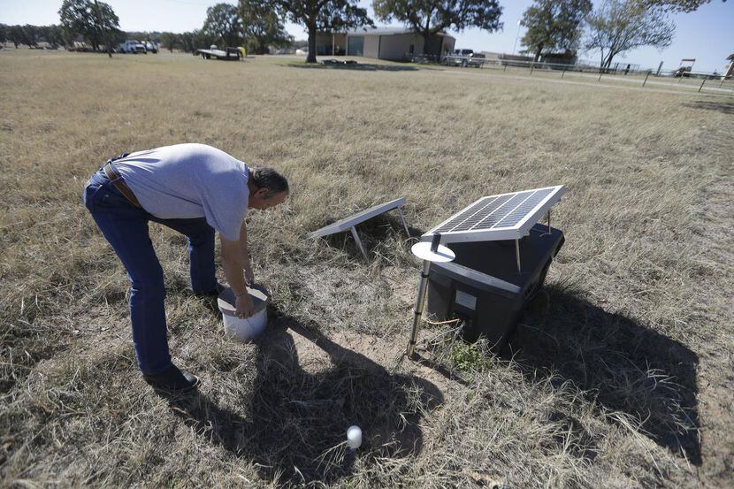 
Scott Passmore, director of public works, checks on a solar powered seismic monitor that...