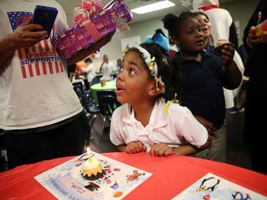 Faith Scott-Flower, 5, waits to blow out her birthday candle during a birthday celebration...