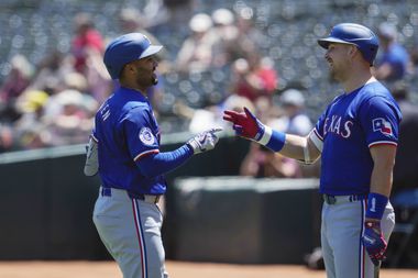 Texas Rangers' Marcus Semien, left, celebrates with Nathaniel Lowe after hitting a solo home...