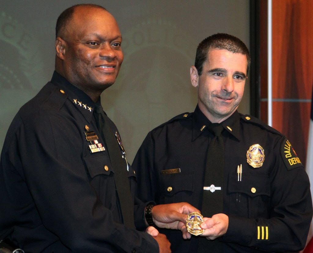 Dallas police Chief David O. Brown, left, hands Deputy Chief David Pughes his new badge at a...