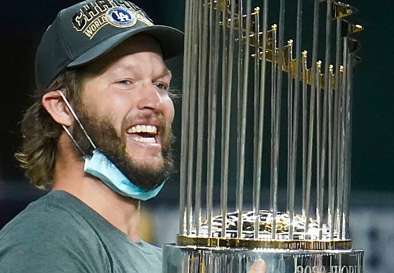 Los Angeles Dodgers starting pitcher Clayton Kershaw celebrates with the championship trophy...
