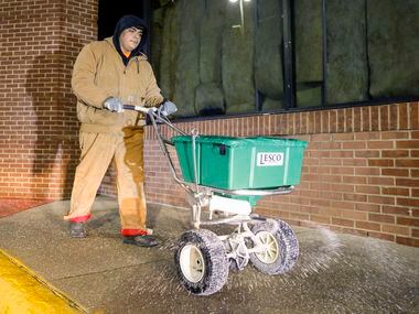 Cesar Montoya of Integrity Porter and Services salts a walkway outside a Fiesta Mart in...