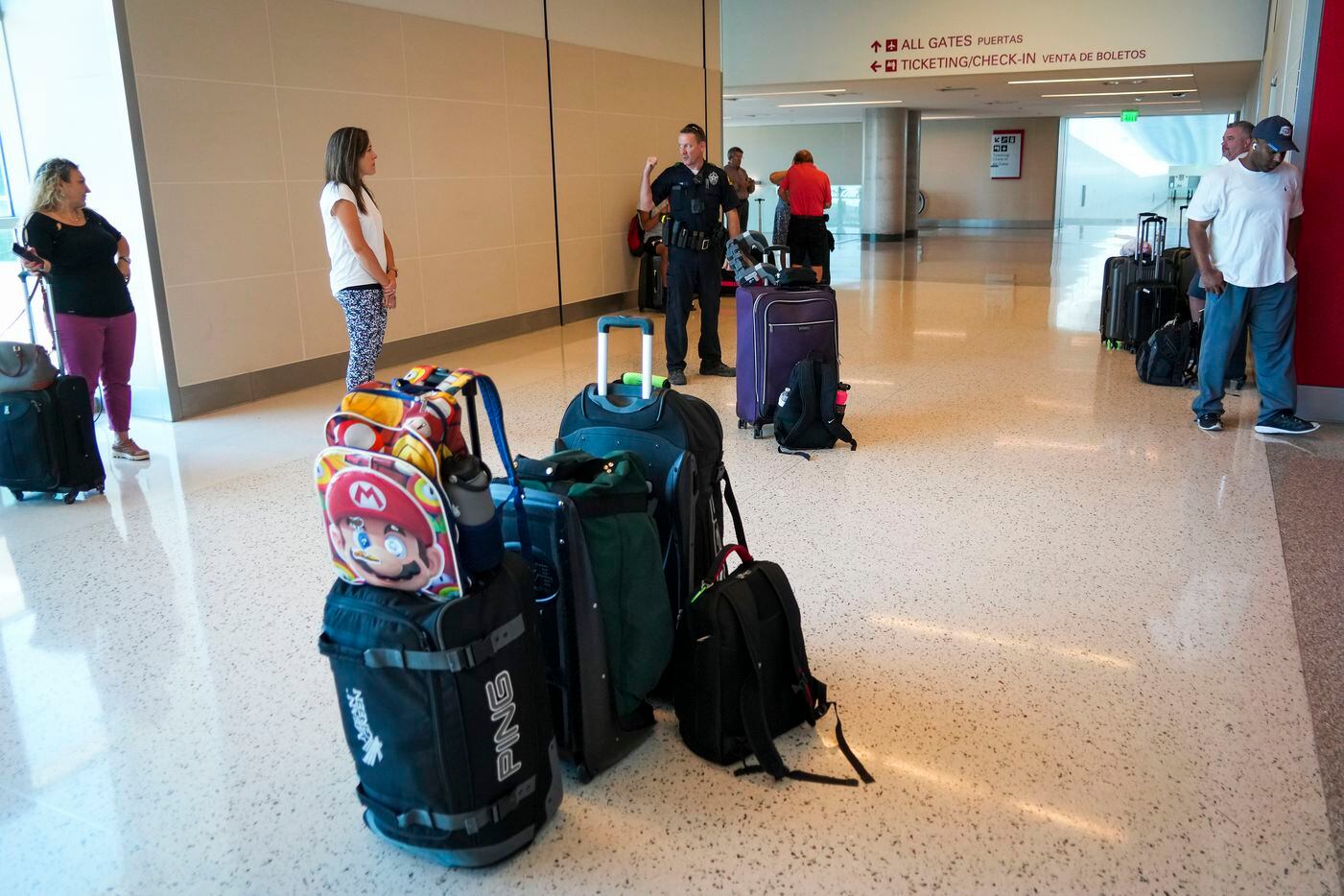 Dallas police direct passengers away from the ticketing hall at Dallas Love Field Airport on...