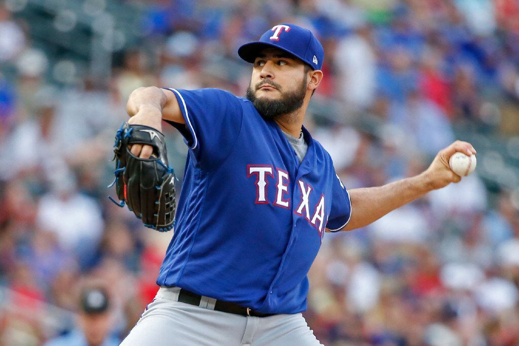 Texas Rangers starting pitcher Martin Perez throws to the Minnesota Twins in the first...
