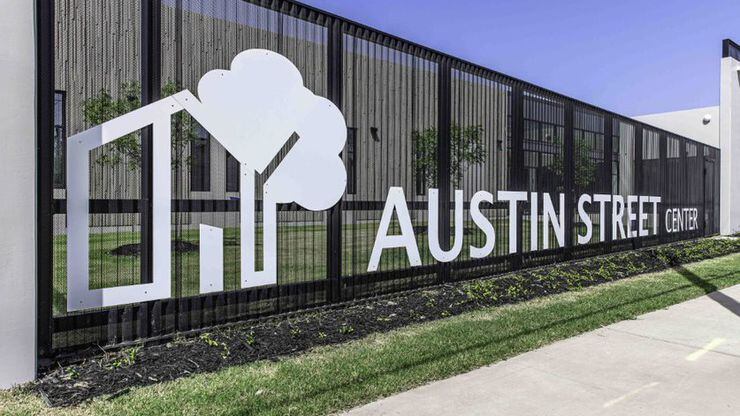 Black iron fence with the words Austin Street Center across it.