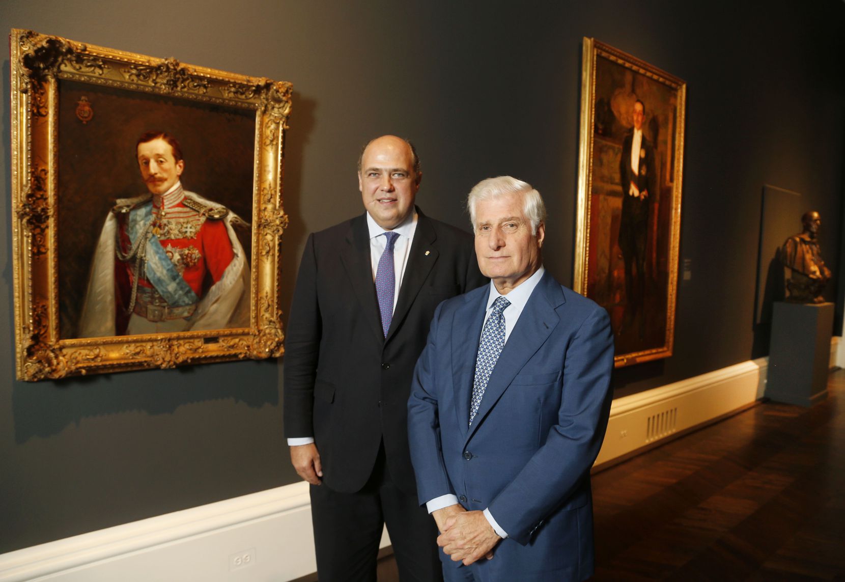 Roglán and the 19th Duke of Alba pose before portraits of the 16th (left) and 17th (right) Dukes of Alba at "Treasures From the House of Alba: 500 Years of Art and Collecting."