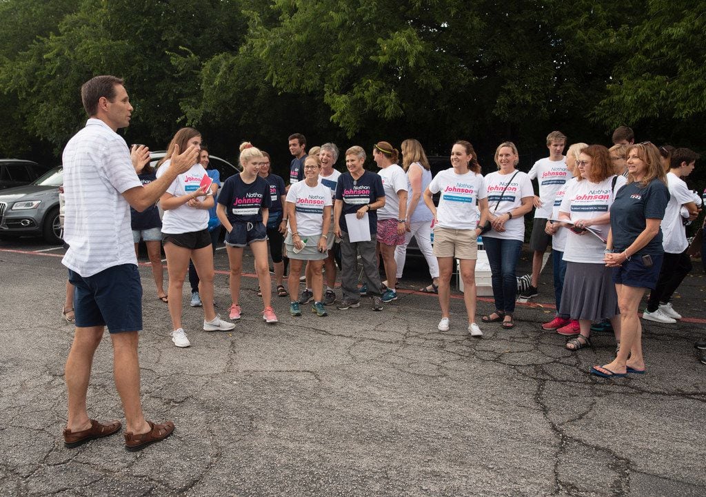 Nathan Johnson, left, talks with volunteers before they set out to canvass a neighborhood on...