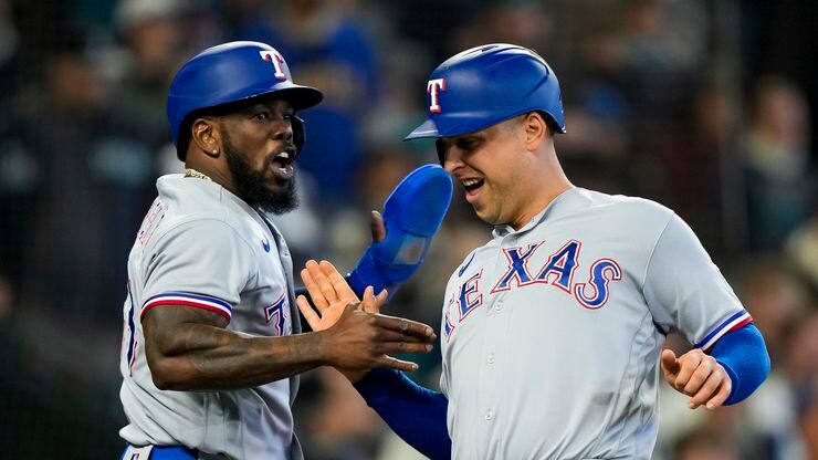 Texas Rangers' Adolis García, left, greets Nathaniel Lowe as they score on a two-run double...