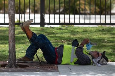 A man rests under the shade of a tree while working on Haskell Avenue between Live Oak...