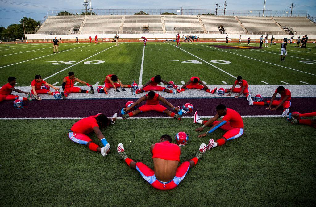 Carter football players stretch before a 4A high school football game between Carter and...